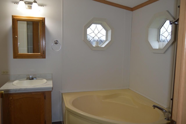 bathroom with crown molding, a tub to relax in, and vanity