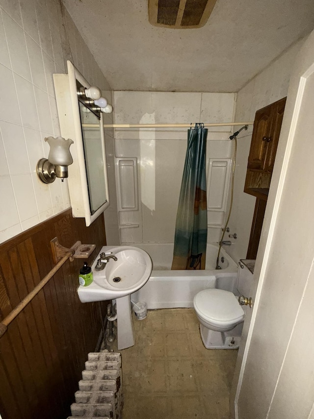 full bathroom with visible vents, toilet, tile patterned floors, shower / bathtub combination with curtain, and a sink