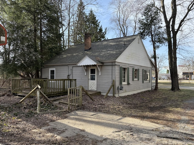 5312 Airline Rd, Muskegon, MI 49444 - back of house with a chimney, a wooden deck, and roof with shingles