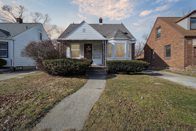 bungalow-style house featuring a front lawn