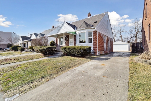 view of front of property featuring a garage, an outdoor structure, and a front yard