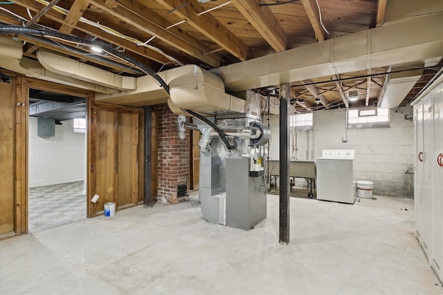 basement featuring washer / clothes dryer, electric panel, sink, and heating unit