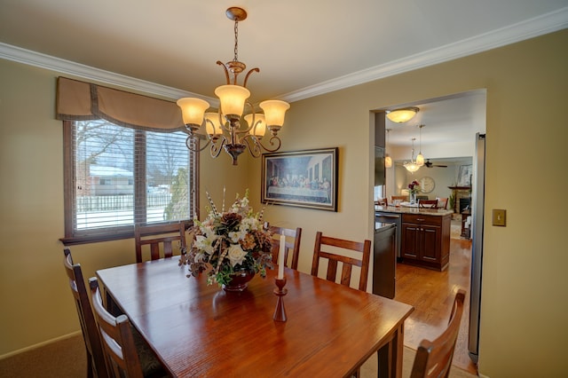 dining area with ornamental molding, an inviting chandelier, and light wood-type flooring