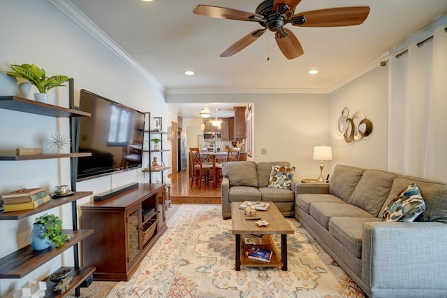 living room with ornamental molding, light hardwood / wood-style floors, and ceiling fan