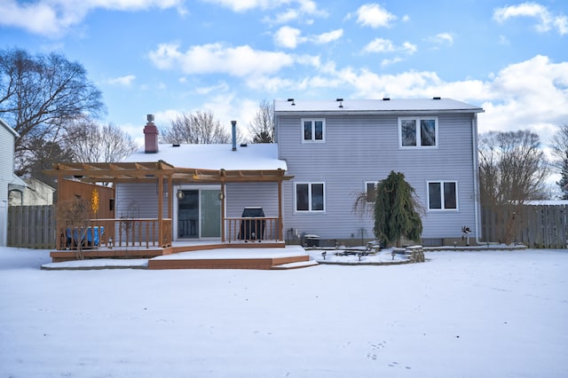 snow covered house featuring a deck and a pergola