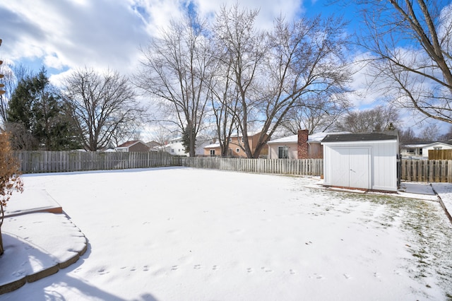 yard covered in snow with a shed