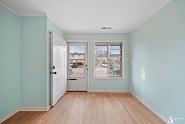 doorway to outside featuring ornamental molding and light hardwood / wood-style floors