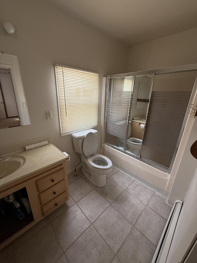 full bathroom featuring toilet, vanity, shower / bath combination with glass door, and tile patterned flooring