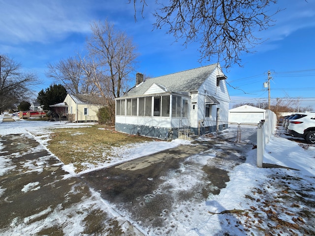 view of front of house featuring an outbuilding, a garage, and a sunroom