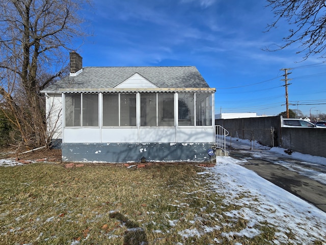 exterior space featuring a sunroom and a lawn