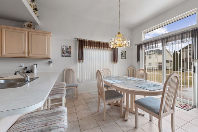 tiled dining space featuring sink and a notable chandelier