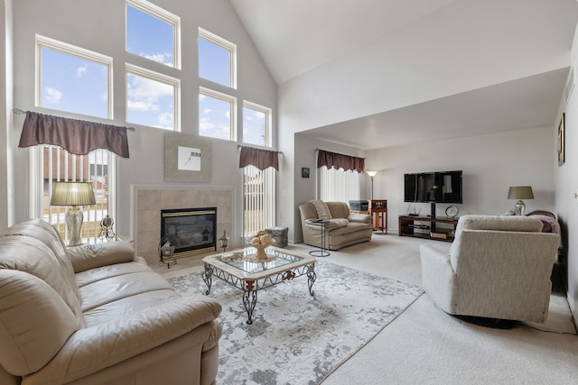 living room featuring a tile fireplace, carpet, and high vaulted ceiling