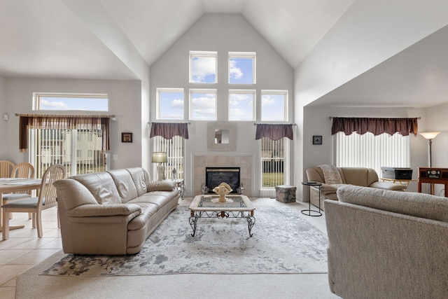 tiled living room featuring a tiled fireplace, high vaulted ceiling, and a wealth of natural light