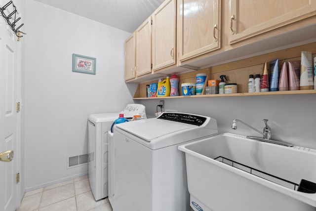 washroom featuring cabinets, independent washer and dryer, sink, and light tile patterned floors