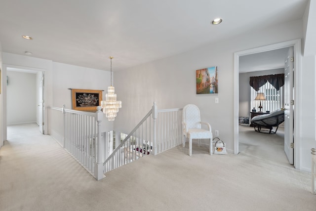 hallway featuring light carpet and an inviting chandelier