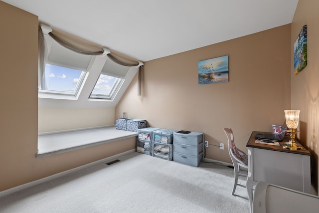 office featuring vaulted ceiling with skylight and carpet