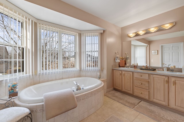 bathroom featuring a relaxing tiled tub, tile patterned floors, and vanity