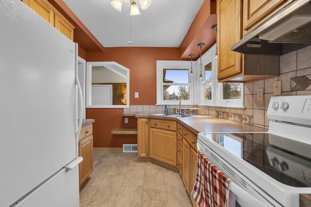 kitchen featuring decorative backsplash, white appliances, sink, and hanging light fixtures