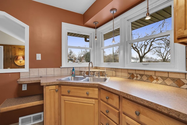 kitchen featuring decorative light fixtures, sink, and decorative backsplash