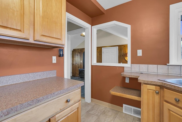 kitchen with tasteful backsplash, sink, and light brown cabinets