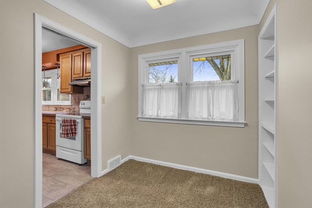 kitchen with white electric range oven, light carpet, and backsplash