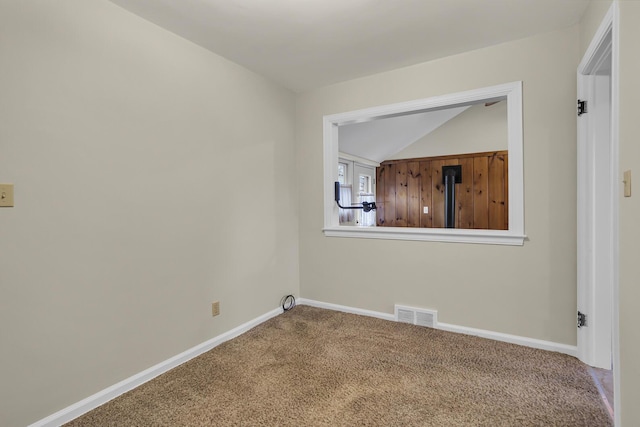 empty room featuring lofted ceiling and carpet