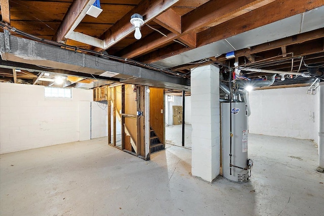 basement with water heater and stairs