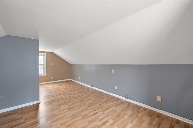 bonus room with lofted ceiling, light wood finished floors, and baseboards