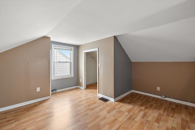 bonus room with lofted ceiling, visible vents, light wood-style flooring, and baseboards