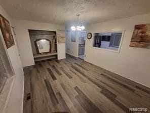 unfurnished dining area featuring dark hardwood / wood-style floors and a chandelier