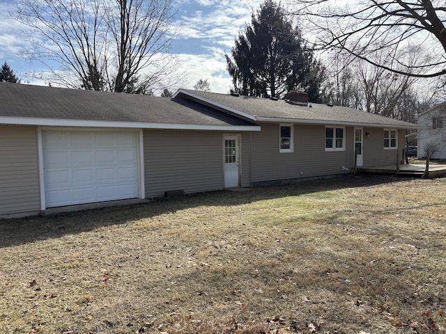 back of house with a garage and a yard