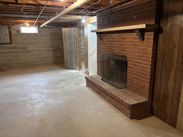 basement with a fireplace and electric panel