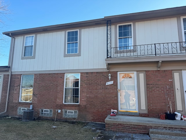 view of front of property featuring central AC and a balcony