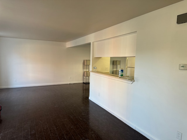 empty room with dark hardwood / wood-style flooring