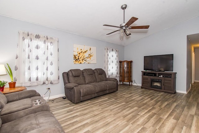 living room with lofted ceiling, hardwood / wood-style flooring, and ceiling fan