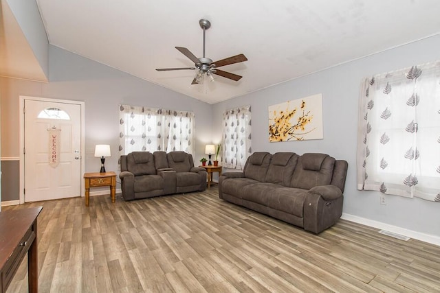 living room featuring lofted ceiling, light hardwood / wood-style flooring, and ceiling fan