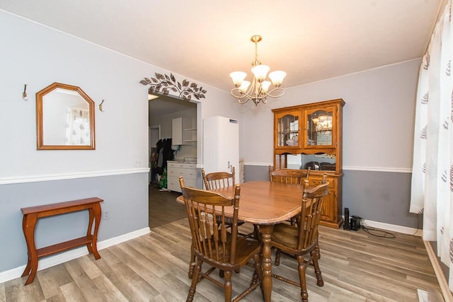 dining area featuring an inviting chandelier and light hardwood / wood-style floors