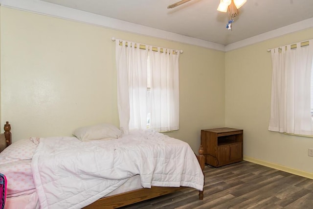 bedroom with dark wood-type flooring, ceiling fan, and ornamental molding