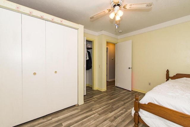 bedroom with crown molding, hardwood / wood-style floors, ceiling fan, and a closet