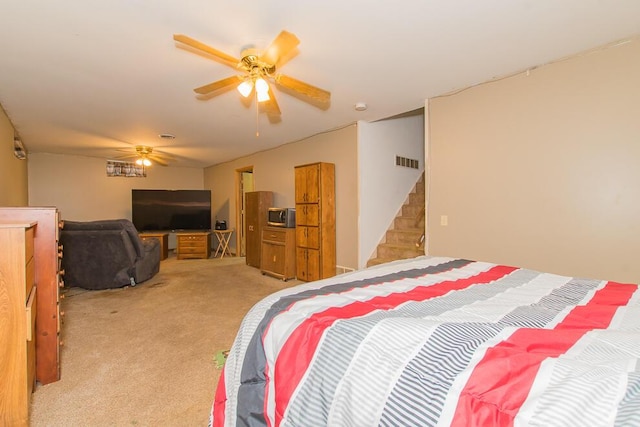 bedroom with ceiling fan and light colored carpet