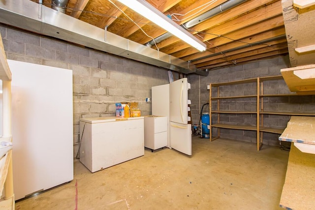 basement featuring refrigerator and white fridge