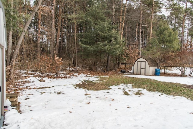 yard layered in snow featuring a shed