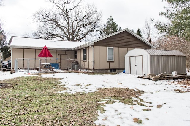 snow covered house with a storage unit