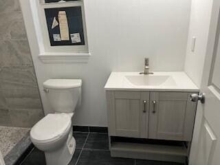 full bath featuring toilet, tile patterned flooring, vanity, and a tile shower