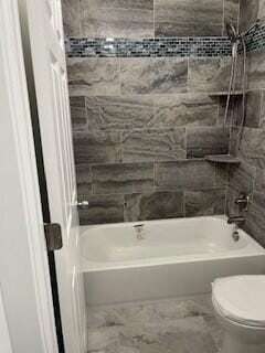 bathroom featuring toilet and shower / washtub combination