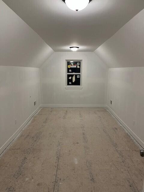 additional living space featuring vaulted ceiling and baseboards