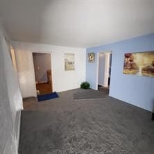 unfurnished living room with dark carpet