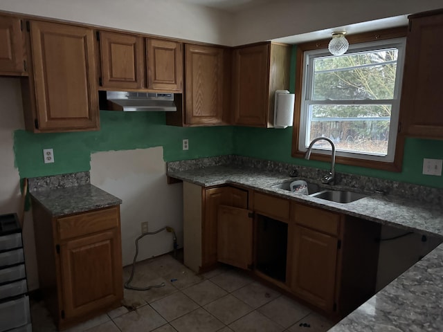 kitchen featuring light tile patterned floors, sink, and dark stone countertops