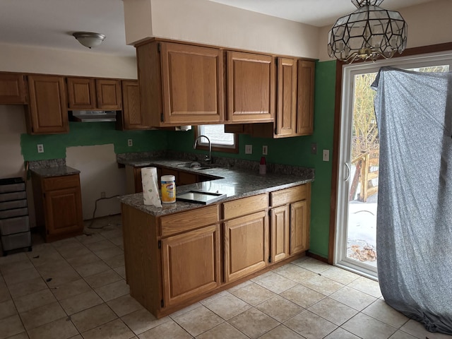 kitchen featuring pendant lighting, sink, light tile patterned floors, and black electric stovetop