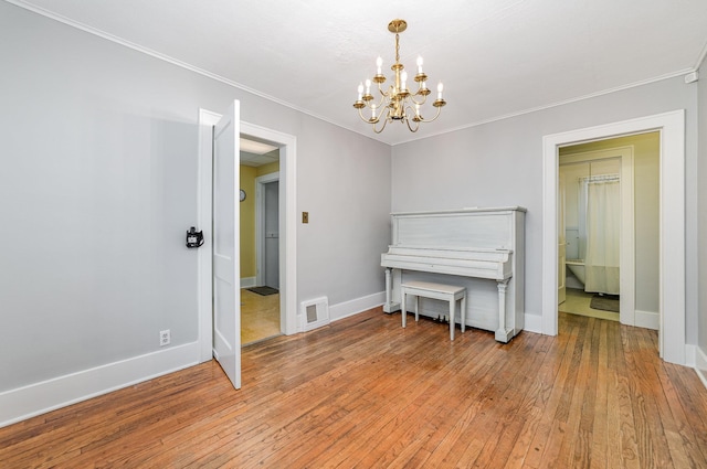 miscellaneous room with ornamental molding, a notable chandelier, and light hardwood / wood-style flooring